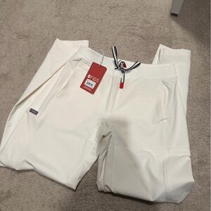 FIGS Cream Scrub Pants with Red Brand Tag